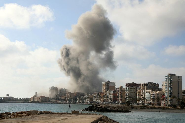 Asap mengepul dari lokasi serangan udara Israel yang menargetkan sebuah lingkungan di kota pesisir selatan Lebanon, Tyre, pada 7 Juni 2026. Israel dan Hizbullah saling baku tembak, tetapi bagian selatan ibu kota Lebanon, termasuk distrik-distrik yang dianggap sebagai benteng Hizbullah, relatif terhindar, hanya dihantam dua kali sejak pertengahan April. Israel kemudian mengeluarkan peringatan evakuasi untuk sebagian besar kota Tyre di selatan Lebanon dan sekitarnya, yang merupakan lokasi serangan yang lebih sering terjadi. 