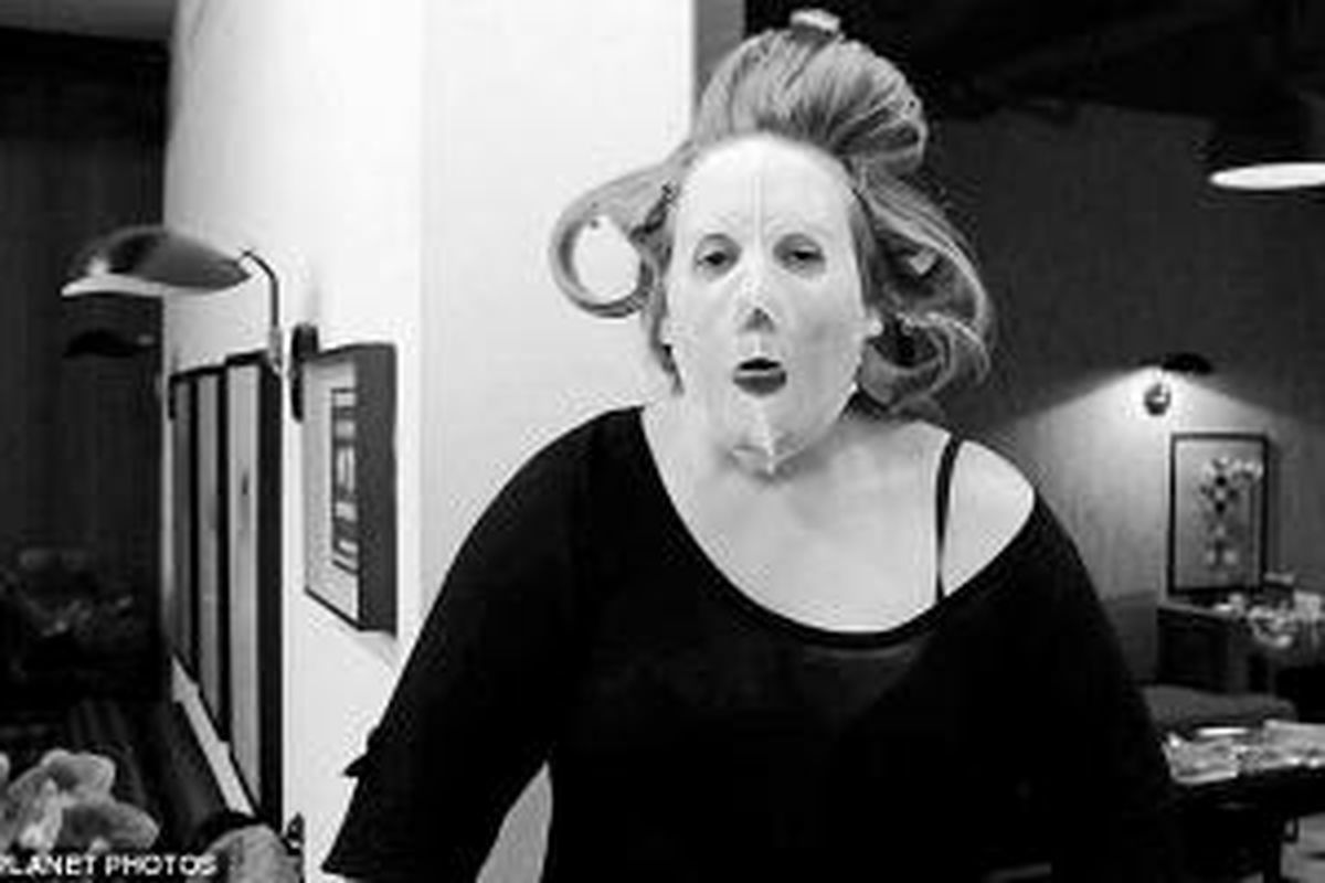 Musisi, Adele, saat mengenakan cheat sheet atau kerta masker. 