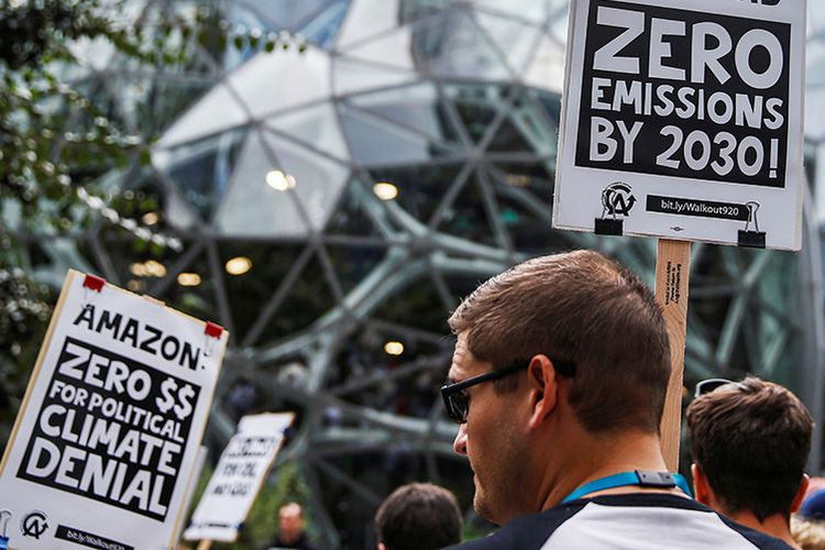 Peserta membawa spanduk memohon agar Amazon mencapai emisi nol pada 2030 di depan Amazon Spheres saat aksi Climate Strike di Seattle, Washington, Amerika Serikat, Jumat (20/9/2019). Aksi Climate Strike 2019 digelar serentak di 163 negara di seluruh dunia, terinspirasi dari Greta Thunberg, remaja aktivis lingkungan yang bersama ribuan murid sekolah lainnya berkampanye tentang penanganan perubahan iklim di Swedia, 2018 lalu.