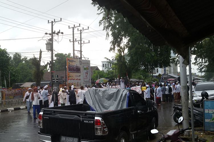 Massa bertahan di depan kantor KPU Kepulauan Bangka Belitung meskipun diguyur hujan, Jumat (26/4/2019).