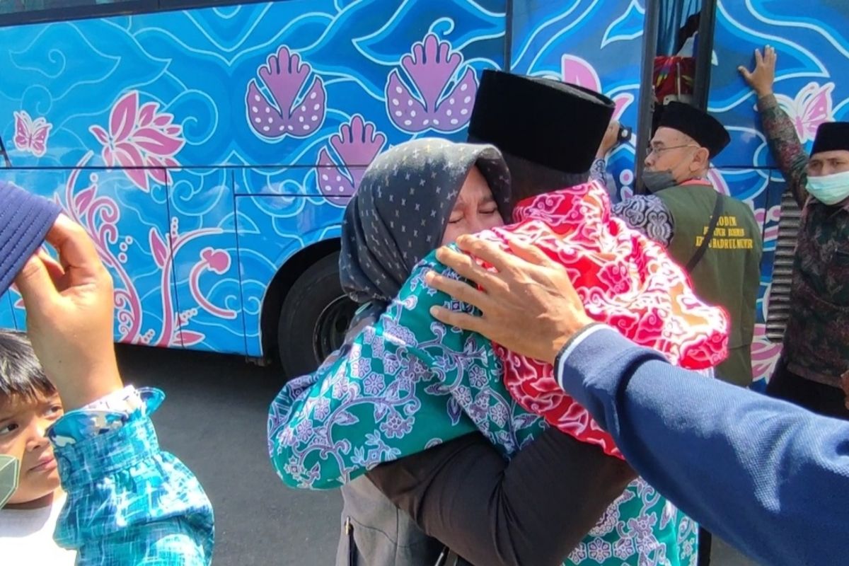 Siti Rohmah (34) menangis di pelukan suaminya Ari Mario Sakti (35) saat hendak masuk bus rombongan ibadah haji. Mario berhaji menggantikan ibunya yang meninggal dunia karena Covid-19. Mario, satu dari 162 jemaah haji diberangkatkan dari halaman Korem 063 Sunan Gunung Jati Cirebon, Kecamatan Kesambi, Kota Cirebon, Selasa (28/6/2022).