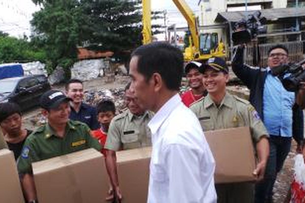 Gubernur DKI Jakarta Joko Widodo saat memberikan bingkisan akhir tahun kepada para penjaga pintu air Manggarai, Selasa (31/12/2013).