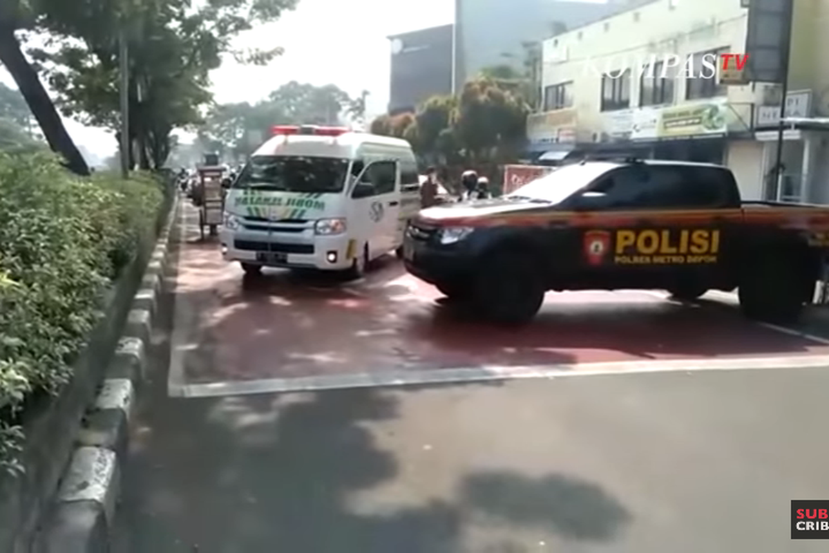 Ambulans yang mengangkut jenazah terhalang penyekatan di Jalan Margonda. Sejumlah ruas jalan disekat selama masa PPKM Darurat. 
