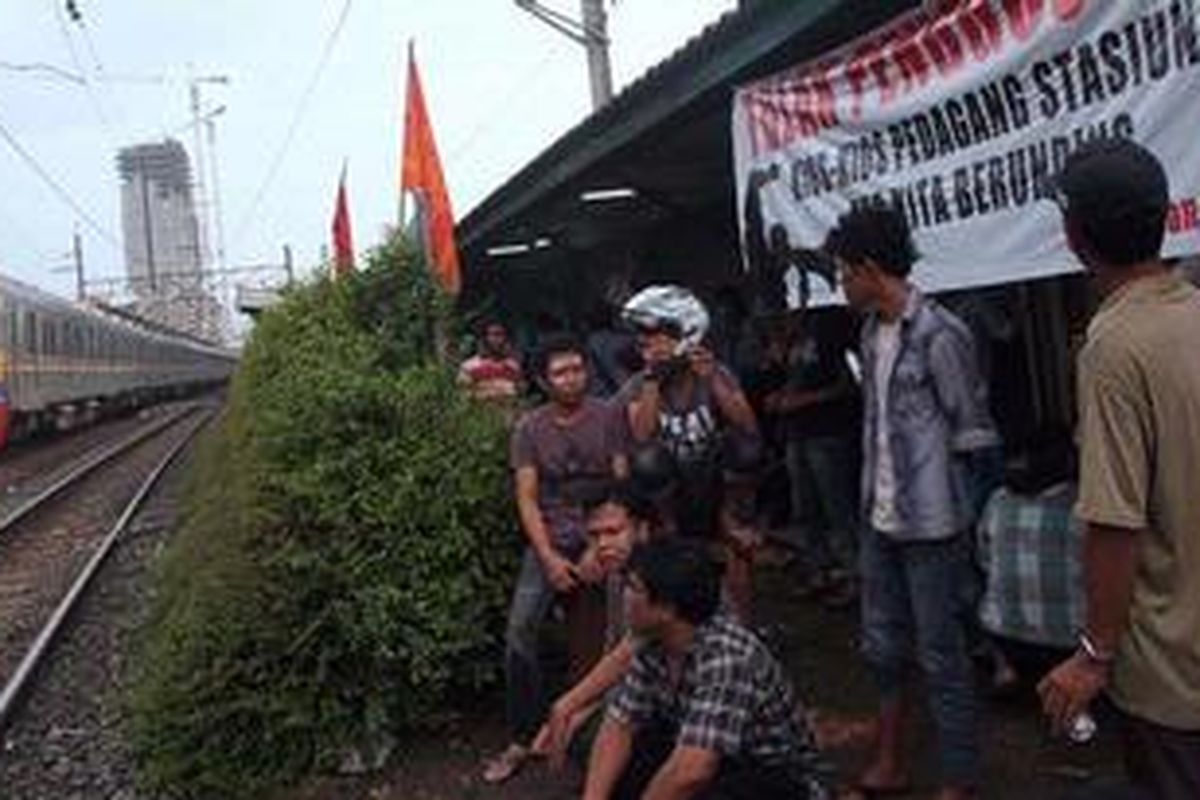 Pedagang bersama Mahasiswa Universitas Indonesia menutup akses menuju kios pedagang di Stasiun Pondok Cina, Depok, Jawa Barat,  yang hendak dibongkar oleh PT KAI Daop 1, Jumat (4/1/2013). Pembongkaran yang rencananya dilakukan hari itu untuk menciptakan rasa aman bagi perjalanan kereta api.   