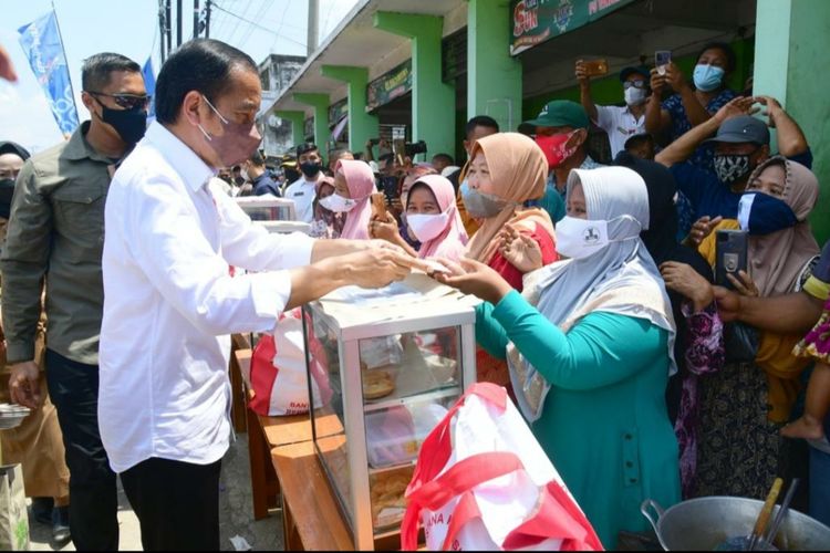 Presiden Joko Widodo saat menyerahkan sejumlah bansos di Pasar Tanjung, Kabupaten Brebes, Jawa Tengah, Rabu (13/4/2022)..
