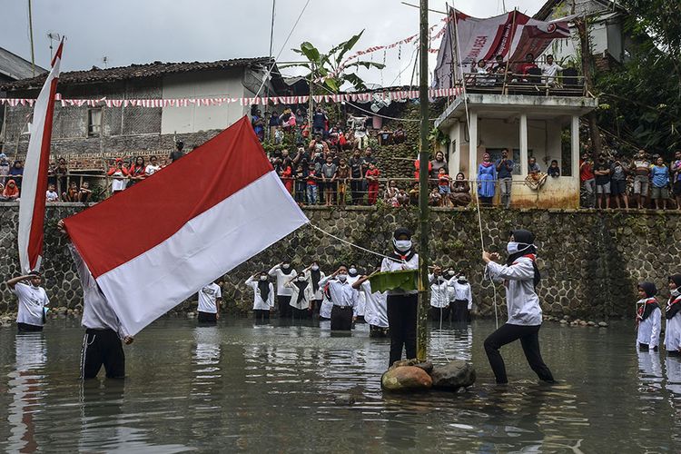 Warga mengibarkan bendera merah putih saat mengikuti upacara bendera di Daerah Aliran Sungai (DAS) Cileueur, Lingkungan Janggala, Kabupaten Ciamis, Jawa Barat, Senin (17/8/2020). Upacara di sungai dengan menerapkan protokol kesehatan COVID-19 itu digelar untuk memperingati HUT Ke-75 RI sekaligus menumbuhkan kesadaran warga untuk peduli terhadap lingkungan agar terbebas dari sampah.