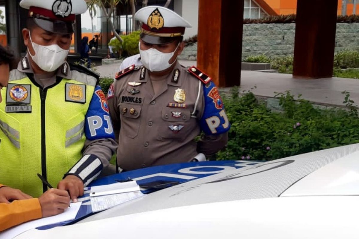 Pengendara motor yang masuk ke jalan tol Jombang - Mojokerto, diminta petugas menandatangani pernyataan setelah dihentikan petugas PJR Polda Jawa Timur, Senin (14/2/2022).