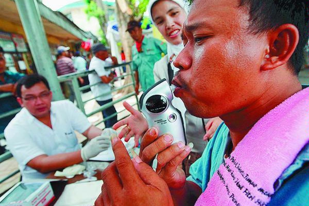 Sopir bus Setyanegara, Kadina, meniup alat pendeteksi alkohol di Posko Terpadu, Terminal Pulo Gadung, Jakarta Timur, Rabu (16/9). Selain alkohol, dalam tes tersebut juga diteliti kandungan obat terlarang melalui tes urine. Sampai pukul 14.00, dari 21 sopir bus, tidak satu sopir pun yang didapati mengandung kedua bahan tersebut dalam tubuh mereka.
