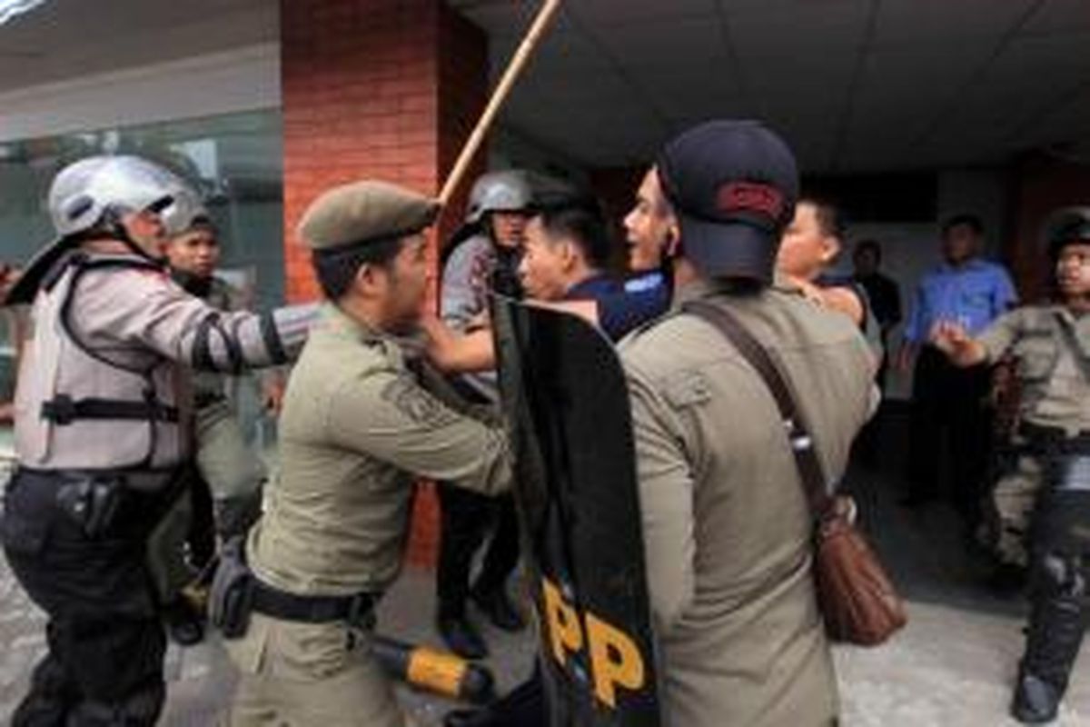 Aparat kepolisian dan Satpol PP bentrokan dengan warga Kampung Pulo, Jakarta Timur, Kamis (20/8/2015). Kerusuhan terjadi karena warga menolak digusur dan dipindahkan untuk normalisasi Kali Ciliwung.