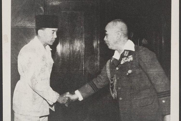 Soekarno (kiri) berjabat tangan dengan Direktur Dalam Negeri Jepang untuk Hindia Belanda, Mayor Jenderal Moichiri