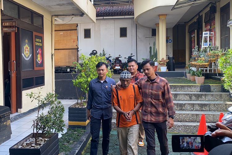 Engkos (tengah) saat digiring keruangan unit PPA Sat Reskrim Polres Sukabumi Kota untuk dimintai keterangan. Kamis (13/6/2024)