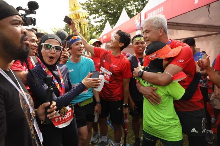 Siti Atikoh menyambut suami tercinta, Gubernur Jateng Ganjar Pranowo di garis finish pada virgin half marathonnya, Minggu (13/11/2022).