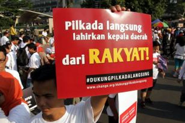 Aktivis yang tergabung dalam Koalisi Kawal RUU Pilkada melakukan aksi damai dan pengumpulan tanda tangan dari warga yang sedang menikmati car free day di sekitar bundaran HI Jakarta Pusat, Minggu (14/9/2014). Mereka mengajak warga untuk menolak RUU Pilkada yang menghilangkan Pilkada langsung selain itu mengembalikan Pilkada kepada DPRD berarti kemunduran dalam partisipasi politik rakyat dan demokrasi substansial.