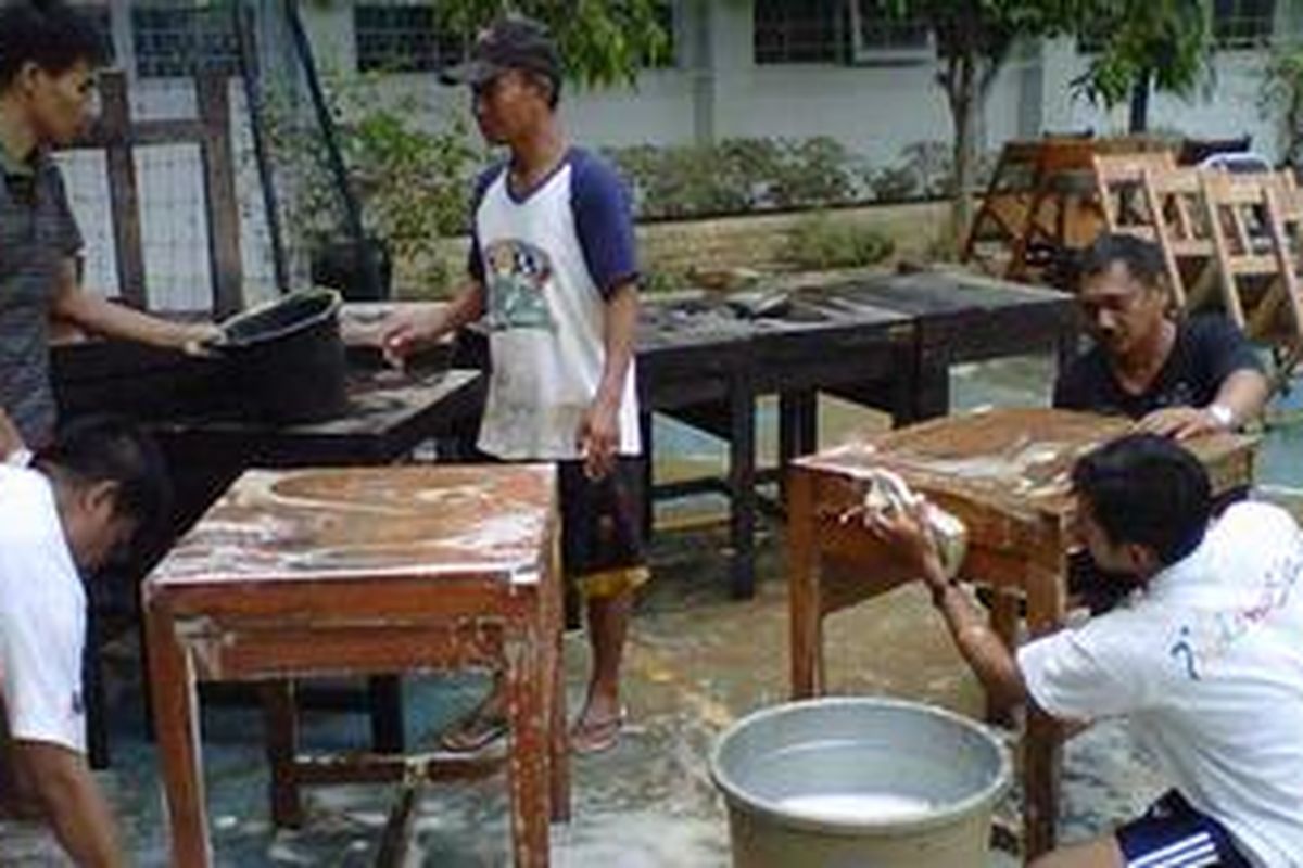 Karyawan dan guru sekolah SMA Negeri 8 Jakarta membersihkan meja dan kursi kelas yang terendam banjir, Senin (21/1/2013). Para siswa yang telah masuk sekolah untuk sementara melakukan kegiatan belajar mengajar di Gedung Diklat DKI Jakarta, Kuningan.