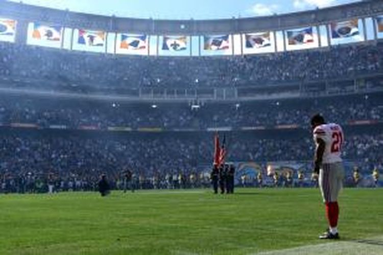 Ryan Mundi (21) pemain klub American Football New York Giants menundukkan kepala bersama seluruh penonton di Stadion Qualcomm, San Diego, AS, untuk menghormati Nelson Mandela sebelum pertandingan melawan San Diego Charger, Minggu (8/12/2013).