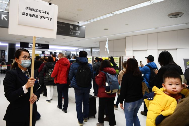 Penumpang yang menggunakan penerbangan terakhir dari Kota Wuhan, China, berjalan melalui alat pengukur kesehatan untuk mencegah masukknya virus Corona, di Bandara Narita, Tokyo, Jepang, 23 Januari, 2020.