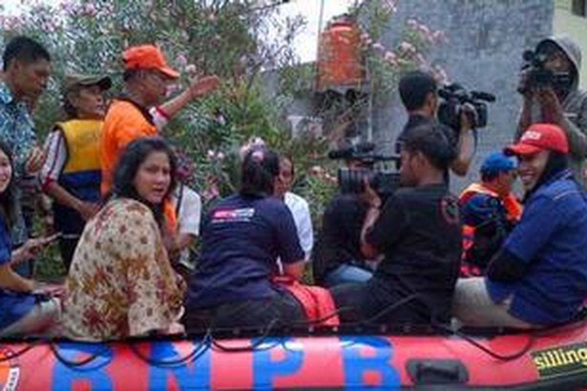 Isteri Gubernur DKI Joko Widodo, Iriana Widodo (menggunakan blouse bermotif bunga) naik perahu karet bersama Jokowi, di Bidara Cina, Jakarta, Senin (24/12/2012).