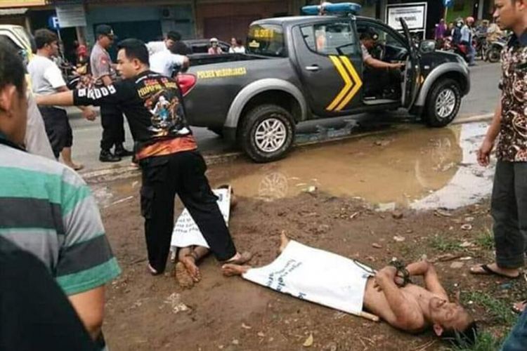 Polisi mengeluarkan dua orang lelaki yang dipergoki  dalam kondisi telanjang di jok tengah mobil Suzuki Ertiga bernopol B 2254 KFB yang terpakir di depan pasar Trangkil, Kabupaten Pati, ?Kamis (20/12/2018) siang.?