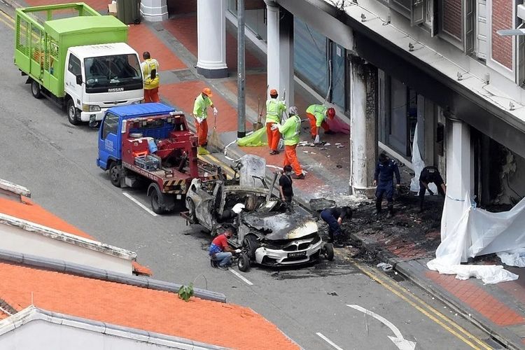 Mobil sedan BMW M4 Coupe putih yang terbakar dan meledak dalam kecelakaan maut di Tanjong Pagar, Singapura, pada Sabtu (13/2/2021) terlihat di luar rumah toko (ruko) yang rusak parah akibat hantaman mobil yang dikemudikan Jonathan Long itu. Long dan keempat temannya tewas dalam kecelakaan yang menggemparkan Singapura  