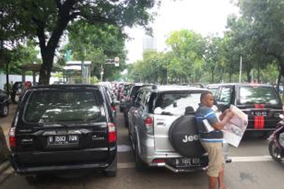 Mobil-mobil yang terparkir sembarangan di badan Jalan Medan Merdeka Selatan, bersamaan dengan pelantikan pejabat Pemprov DKI yang dilaksanakan di Lapangan Monas, Jumat (2/1/2014)