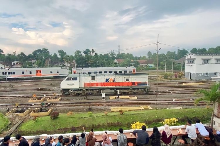 Momen saat gerbong kereta api melintas di depan para pengunjung Kafe Lima Sebelas di Malang. 