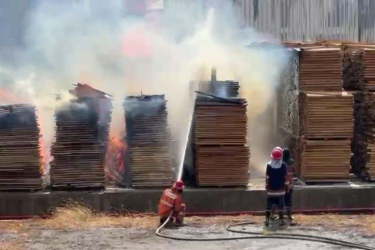 Petugas berusaha untuk memadamkan kobaran api di PT Nankai Indonesia, di Jalan Raya Mayjend Sungkono, Kecamatan Kebomas, Gresik, Jawa Timur, Kamis (12/10/2023).