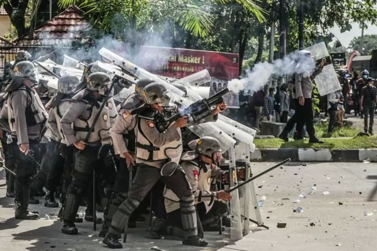 Pasukan polisi menembakkan gas air mata dalam demo di Kendari pada 2021.