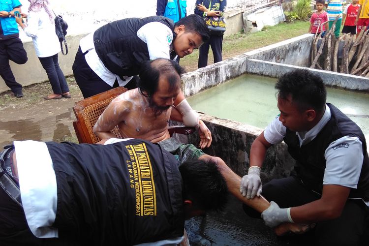 Tim pembebasan pasung saat memandikan Annad (44), salah seorang pengidap gangguan kejiwaan usai dibebaskan dari pasungan di rumahnya di Ngadiluwih, Kabupaten Kediri, Jawa Timur, Rabu (6/4/2017).