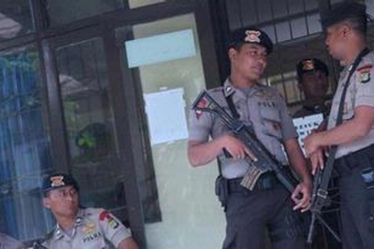 Personil Brimob bersenjata lengkap berjaga di depan pintu  Ruang Perawatan Tahanan Rumah Sakit Pusat Kepolisian R.S. Soekanto, Kramat Jati, Jakarta Timur, tempat tersangka pembunuh bos Sanex Stell, John Kei, dirawat, Selasa (21/2/2012). 