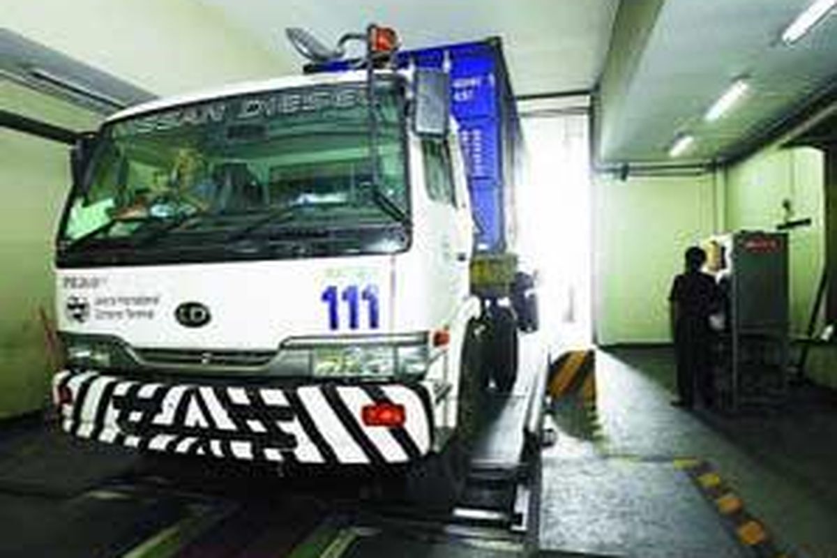 Truk peti kemas ditarik mesin otomatis untuk dipindai di operator fasilitas pemindaian sinar X dengan energi tinggi Direktorat Bea dan Cukai Tanjung Priok, Jakarta Utara, Maret lalu. Banyaknya beban aturan yang ditanggung instansi ini membuat pelayanan menjadi lambat.  