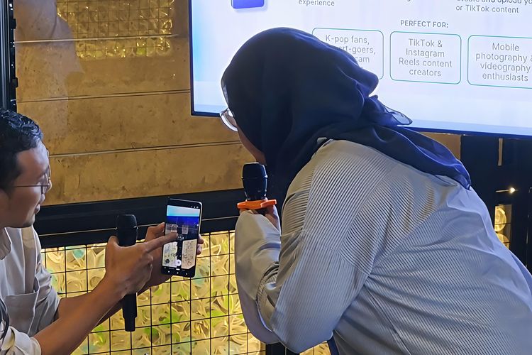 Jurnalis KompasTekno, Galuh Putri memberi tips settingan kamera HP untuk konser kepada seorang pengguna dalam acara Creator Lab Epic Concert, ajang kolaborasi antara Samsung dan Kompas.com yang digelar di bilangan Cipete, Jakarta Selatan, pada Selasa (7/4/2026). 