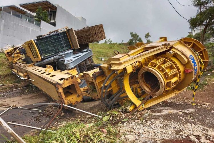 Sebuah alat berat berupa Crane, jatuh dari Tracktor Head (truck pembawa alat berat) usai mengalami selip di Kawasan Dago Resort, Kecamatan Cimenyan, Kabupaten Bandung, Jawa Barat, pada Selasa (14/3/2023)