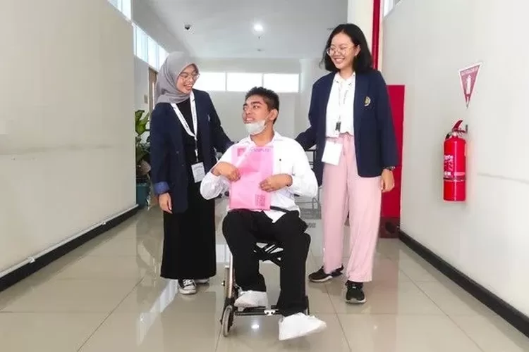 Akbar Pratama, peserta tunadaksa didampingi dua mahasiswa pendamping dari PLB; Mutia Juli Saputri dan Steffany Amelia menuju lokasi tes UTBK, Kamis (2/5/2024)