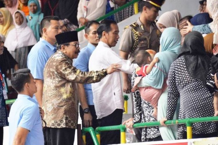 Gubernur Jawa Timur Soekarwo (berkopiah) saat mendampingi Presiden Jokowi berkunjung ke Gresik, Jawa Timur, Kamis (8/3/2018).