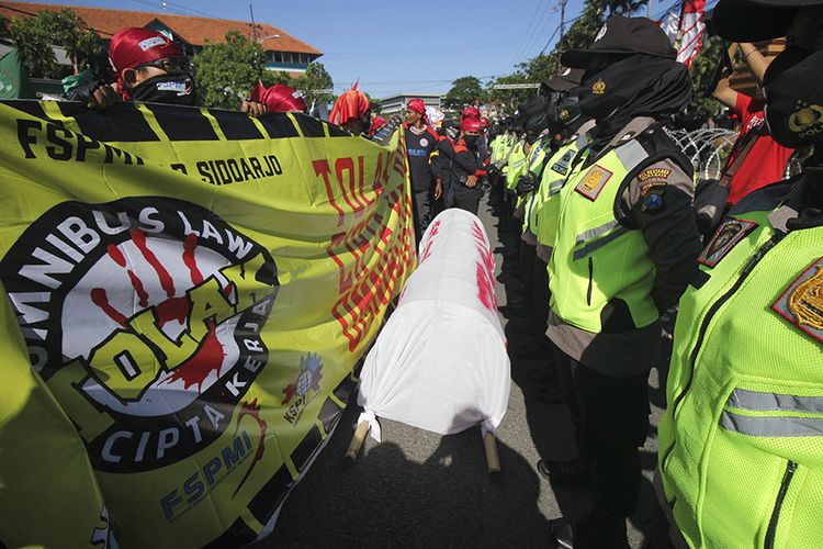 Sejumlah buruh berunjuk rasa di depan gedung DPRD Jawa Timur, Surabaya, Jawa Timur, Selasa (25/8/2020). Massa buruh menyerukan Tolak Omnibus Law.