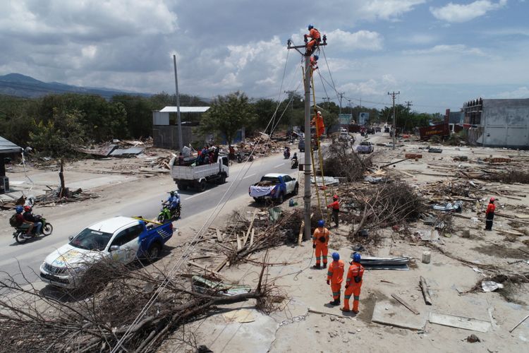 Petugas memperbaiki jaringan listrik di Jalan Trans Sulawesi di Mamboro, Kecamatan Palu Utara, Palu, Sulawesi Tengah, yang putus akibat gempa dan tsunami, Sabtu (6/10/2018). Jaringan listrik di beberapa wilayah di Kota Palu sudah mulai menyala.