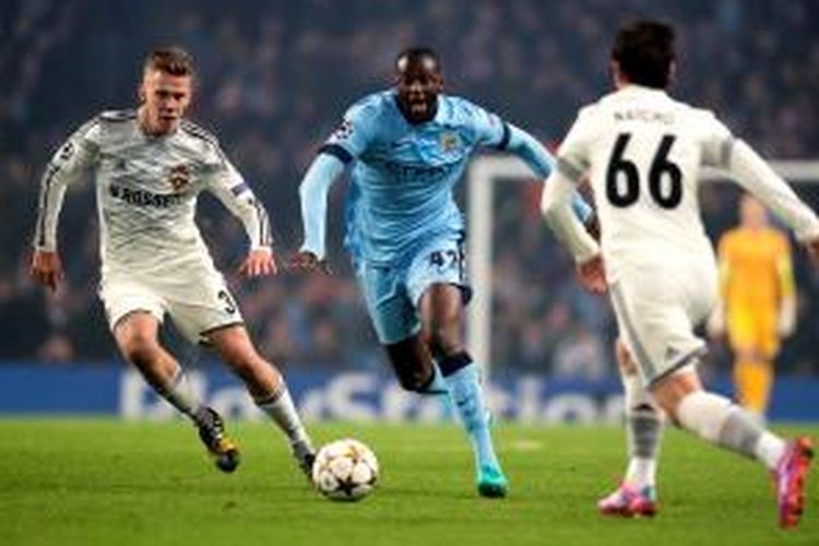 Gelandang Manchester City, Yaya Toure, saat berusaha melewati hadangan pemain CSKA Moskwa pada matchday keempat Grup E Liga Champions di Etihad Stadium, Rabu (5/11/2014). 