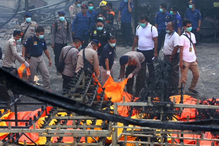 Personel Brimob Polda Metro Jaya mengevakuasi jenazah korban kebakaran pabrik kembang api di Kosambi, Tangerang, Banten, Kamis (26/10/2017). Kebakaran yang diduga akibat ledakan pada salah satu tempat pembuatan kembang api yang baru beroperasi dua bulan ini sedikitnya menewaskan 23 orang karyawan dan puluhan karyawan luka bakar.