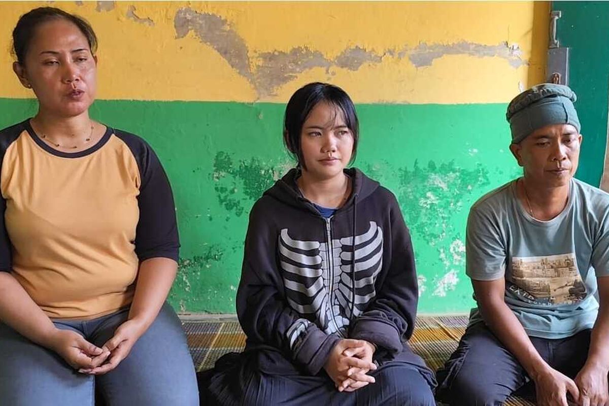 Neisya Fuji Lestari (Hoodie hitam) menangis dan menunjukkan foto ibunya Tasmi, pekerja buruh migran yang meninggal dunia di Malaysia, saat ditemui Kompas.com di rumahnya pada Sabtu (12/7/2025) siang.