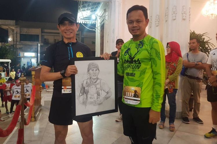 Wali Kota Bogor Bima Arya Sugiarto memberikan kenang-kenangan kepada pelari ultra yang juga hiperman Indonesia Hendra Wijaya di Kantor Wali Kota Bogor, Sabtu (10/6/2017) malam. 