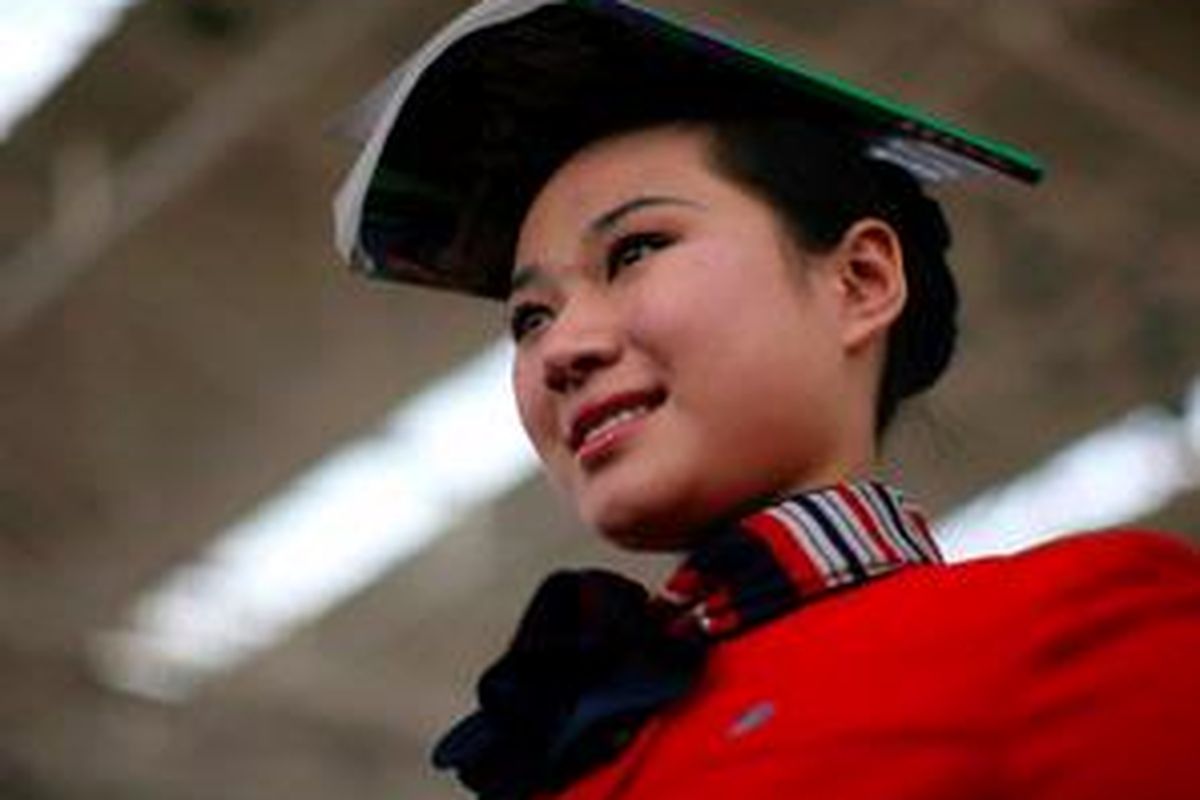 Seorang siswi berlatih menyeimbangkan buku sambil mempertahankan senyumnya, untuk persiapan Olimpiade Beijing 2008.