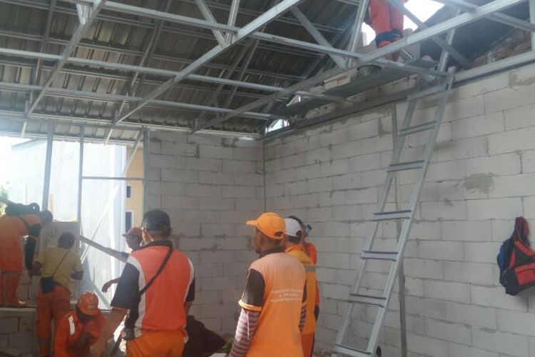 Pasukan merah dan petugas PPSU sedang melakukan pemasangan atap dan tembok di rumah-rumah yang termasuk dalam program bedah rumah yang dicanangkan Pemprov DKI Jakarta, Jumat (5/5/2017)