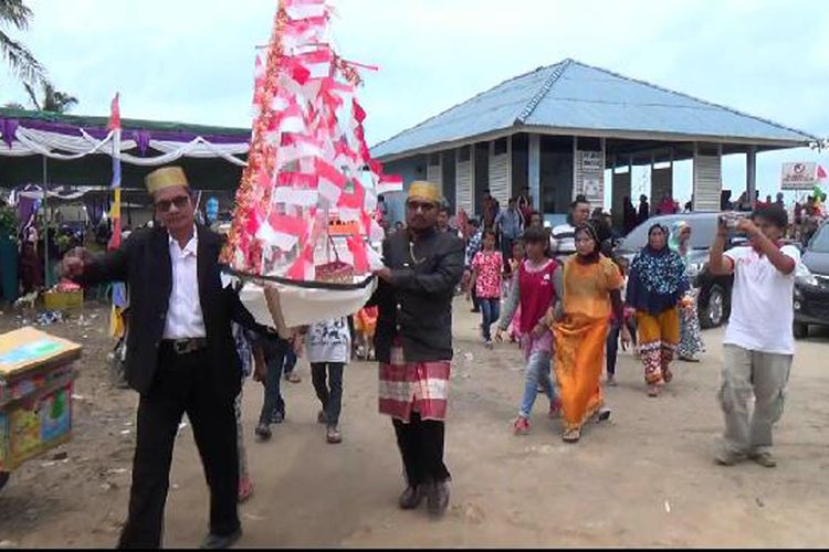 Pemuka adat membawa miniatur perahu saat tradisi syukur laut di Desa Batu Belubang Bangka Tengah, Kepulauan Bangka Belitung