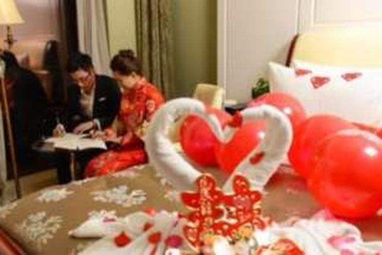 Dalam salah satu foto yang diunggah ke internet ini terlihat pasangan Li Yunpeng dan Chen Xuanchi asyik menyalin konstitusi Partai Komunis China di malam pengantin mereka.