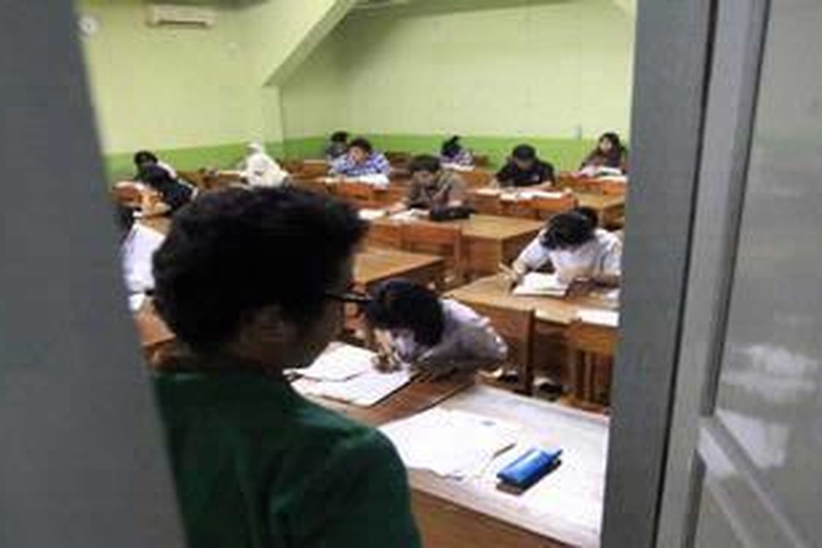 Pengawas dari Universitas Islam Negeri Jakarta mengawasi calon mahasiswa yang tengah mengikuti ujian Seleksi Nasional Masuk Perguruan Tinggi Negeri (SNMPTN) di Sekolah Menengah Atas Negeri 82, Jalan Daha II, Kebayoran Baru, Jakarta Selatan, Selasa (31/5/2011). Tercatat ada sekitar 320 siswa yang mengikuti ujian di SMAN 82. Dari data ada total 540.928 peserta yang akan berjuang hingga 1 Juni 2011 besok untuk memperebutkan 110.149 kursi di 60 perguruan tinggi negeri. 