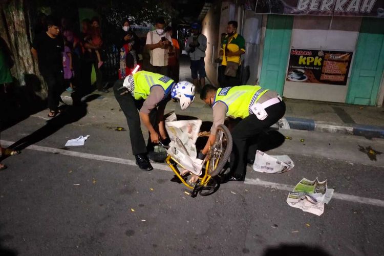 Aparat kepolisian mengevakuasi pesepeda Machmud yang terlibat kecelakaan maut di Jalan Gatot Subroto Nganjuk, Selasa (12/10/2021) malam. Foto: Humas Polres Nganjuk