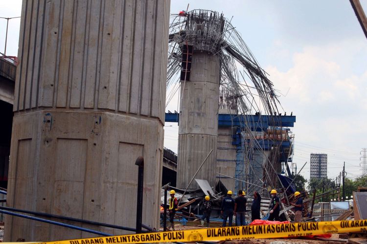 Petugas dari kepolisian mengecek kondisi pasca robohnya cetakan beton tiang pancang proyek Jalan Tol Becakayu, di Jalan DI Panjaitan, Jakarta, Selasa (20/02/2018). Peristiwa tersebut terjadi pada pukul 03.00 WIB saat pekerja sedang melakukan pengecoran. Peristiwa tersebut menyebabkan tujuh pekerja mengalami luka.