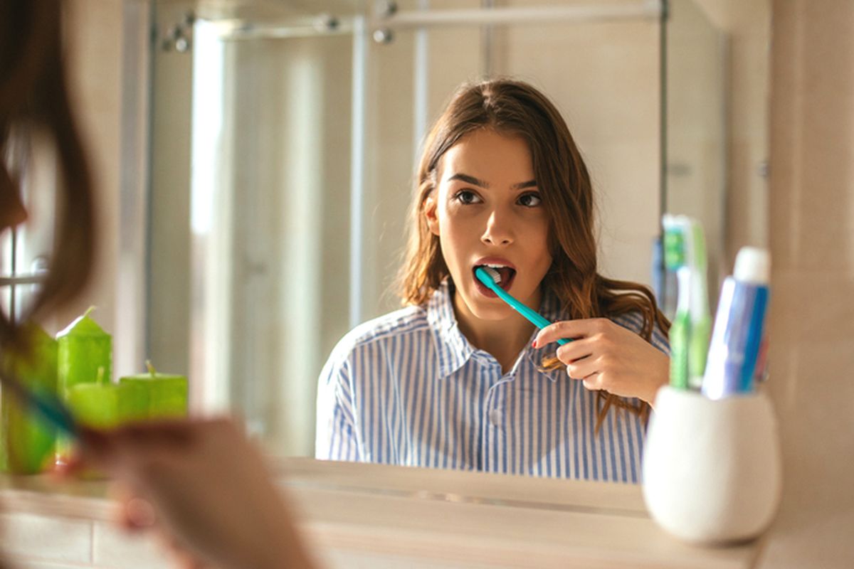 Ilustrasi menyikat gigi untuk menjaga kesehatan gigi.