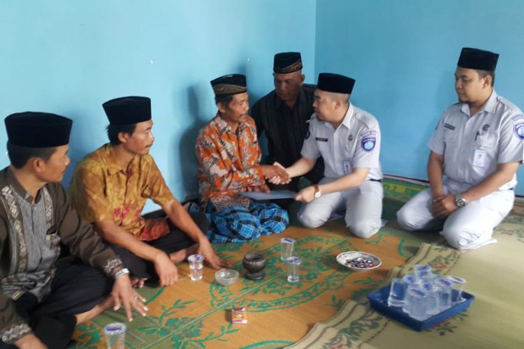 Kepala Perwakilan Jasa Raharja Madiun, Hendra Yudistira menyerahkan santunan kepada Slamet, ayahanda almarhum Alfiani Hidayati Solikah, pramugari korban kecelakaan pesawat Lion Air JT 610 di rumah duka Desa Mojorejo, Kecamatan Kebonsari, Kabupaten Madiun, Jawa Timur, Rabu ( 14/11/2018).