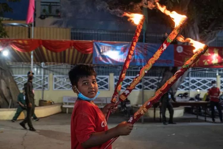 Seorang anak laki-laki memegang hio di Phnom Penh, Kamboja.